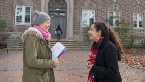 Two students talking in front of Bartlett Hall.