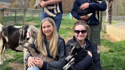 Students holding baby goats.